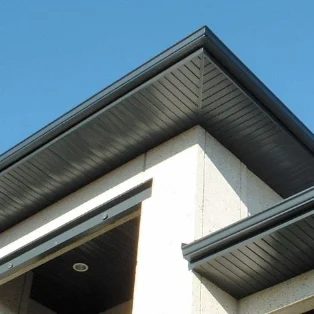 Dessous de toit sombre posé sur une maison à façade claire